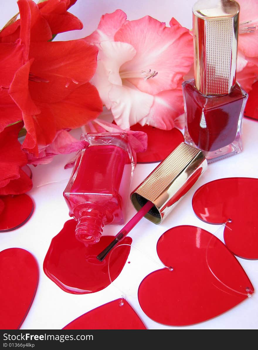 Two nail polish on white background and flowers around