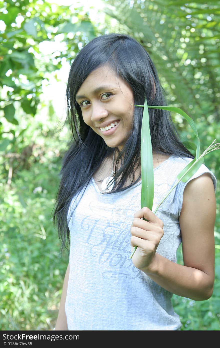 Sweet asian holding grass in nature. Sweet asian holding grass in nature