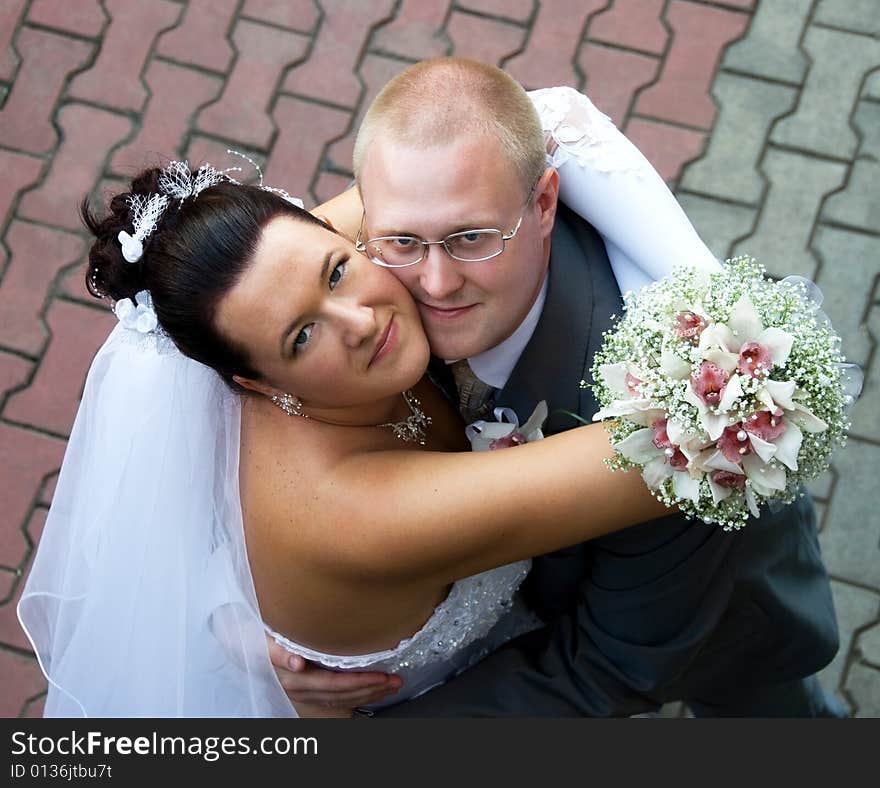 Bride and groom embracing outdoor