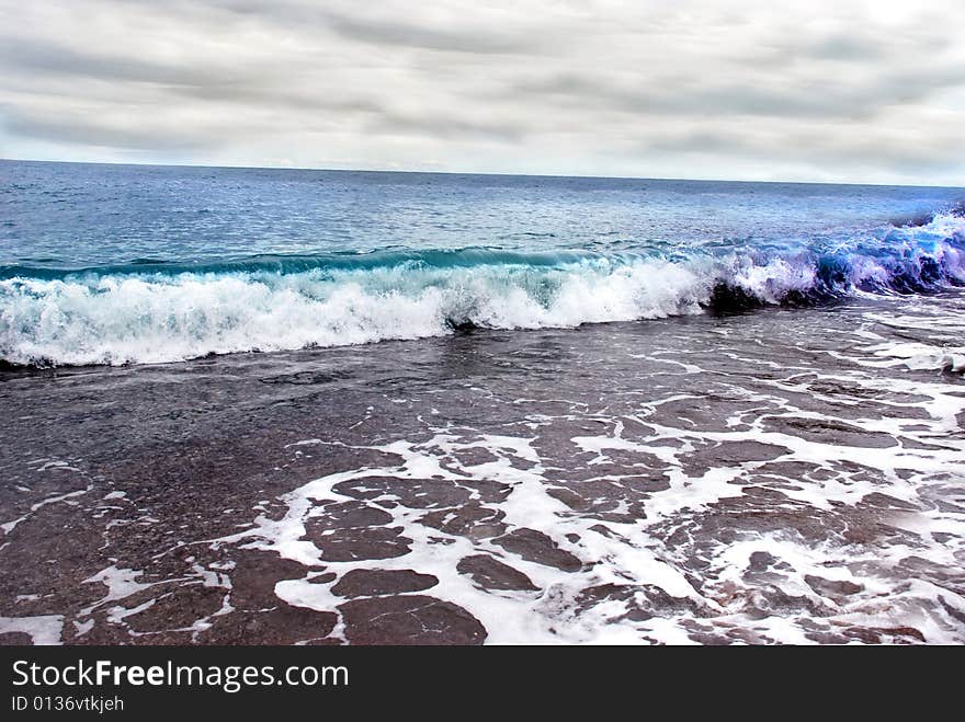 Sea wave and cloudy sky