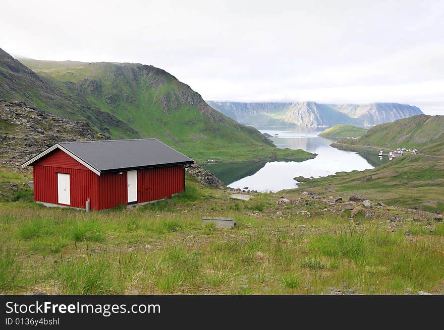 Red wooden cabin in northern Norway. Mountain scenery.