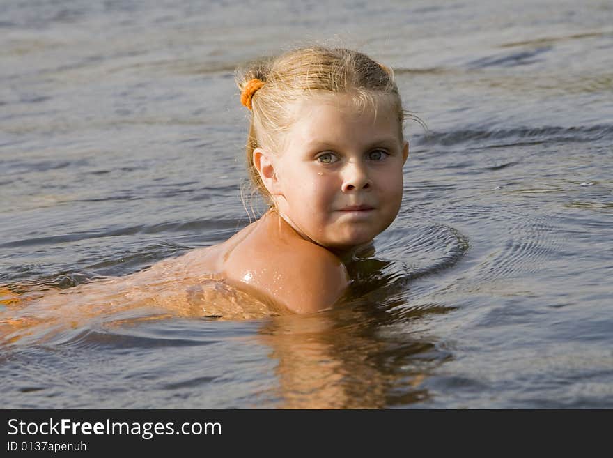 Little girl swimming in a river in the summer. Little girl swimming in a river in the summer