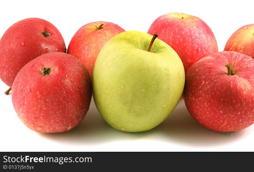 A lot of red and one green apple on a light background. A lot of red and one green apple on a light background