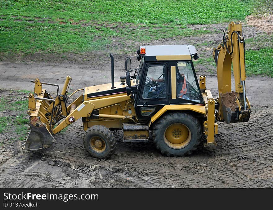 Construction Vehicle. Green grass in the background. Construction Vehicle. Green grass in the background