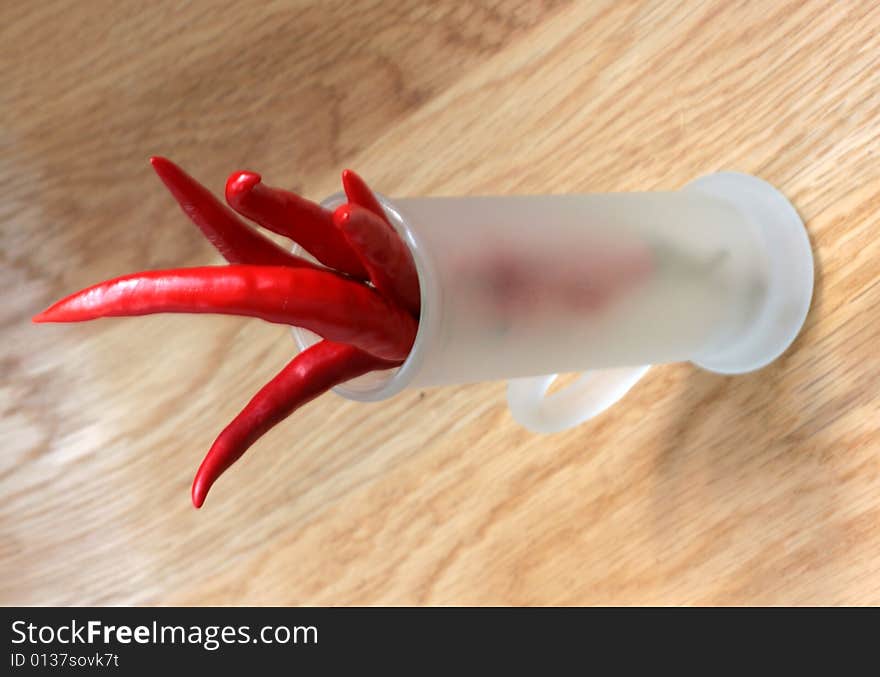 Red peppers in a frosted glass on wood table