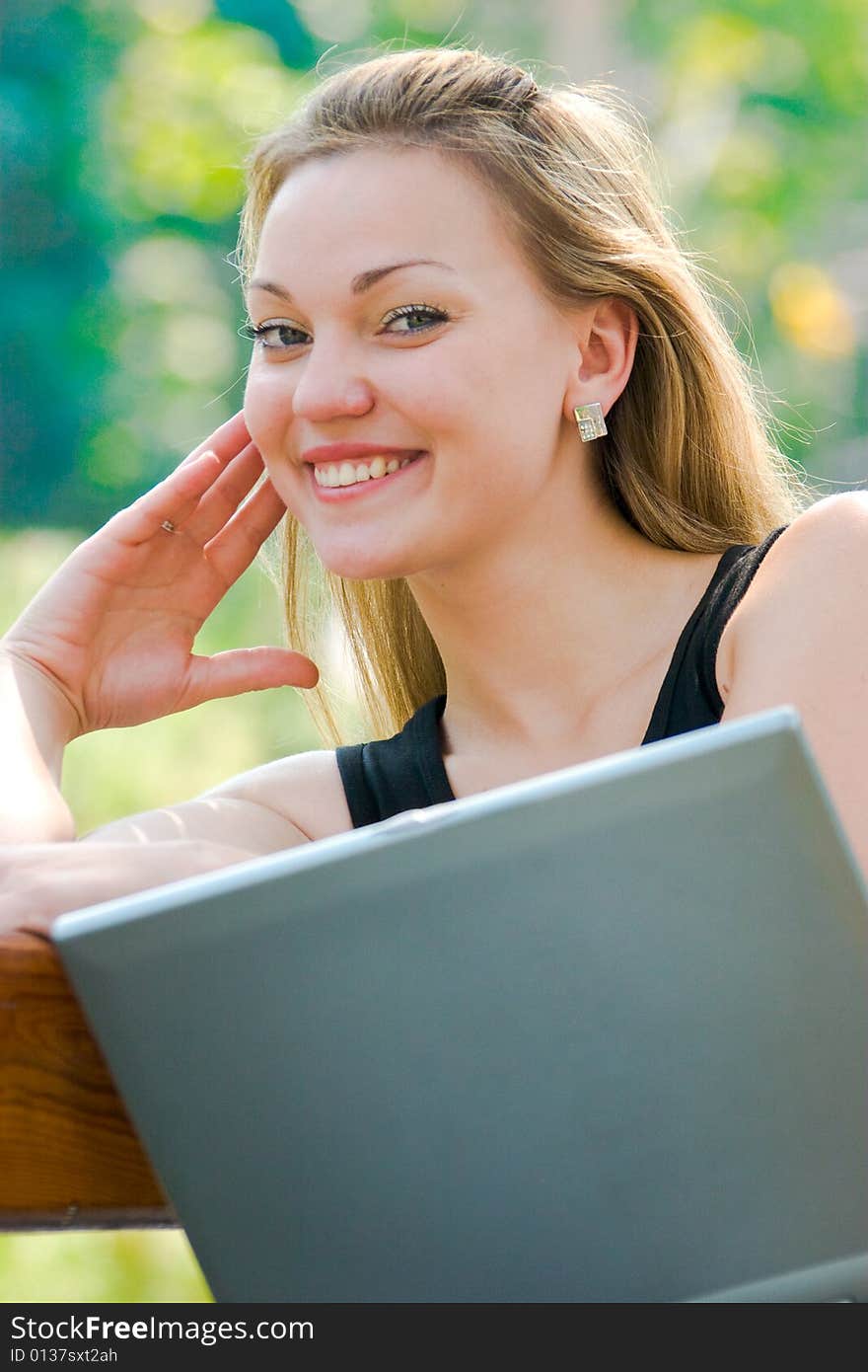 Happy young woman with laptop outdoors shot