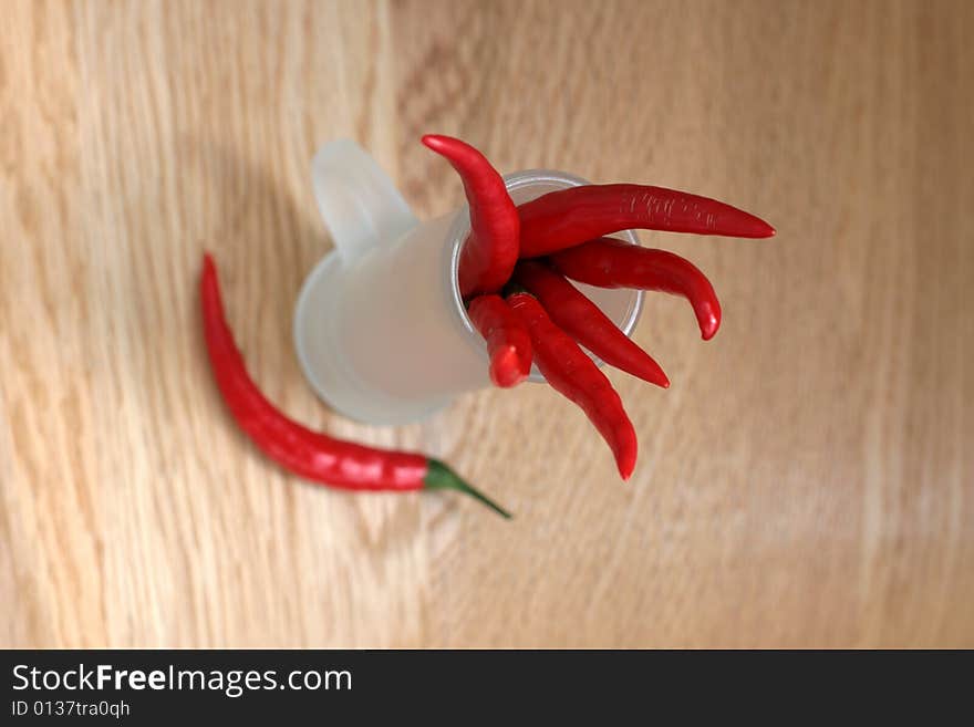 Red peppers in a frosted glass on wood table