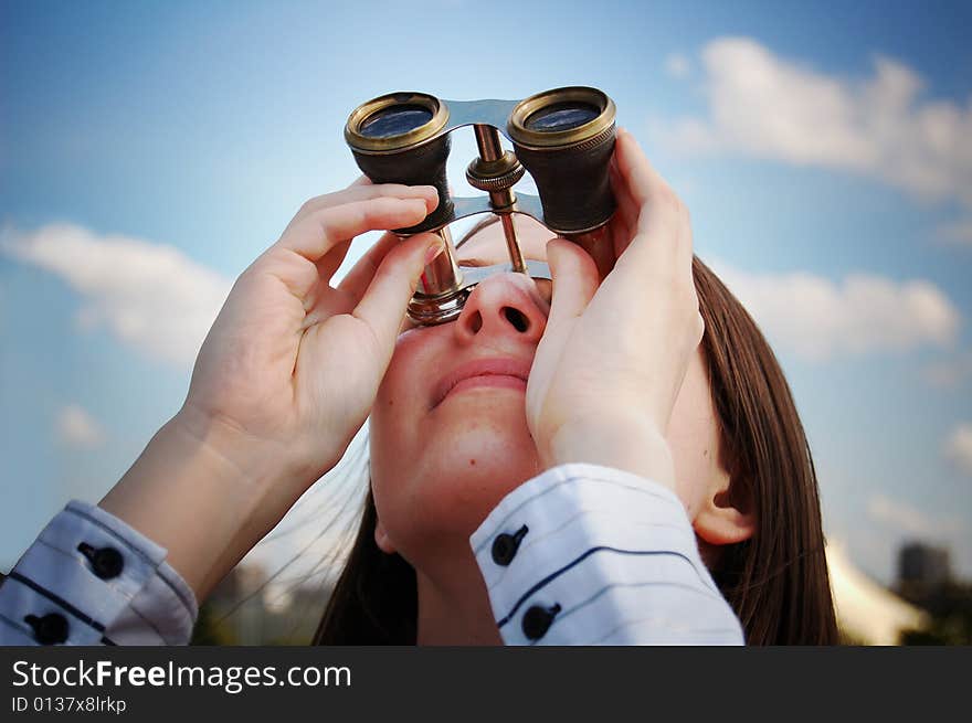 Girl with binocular against cloudy sky