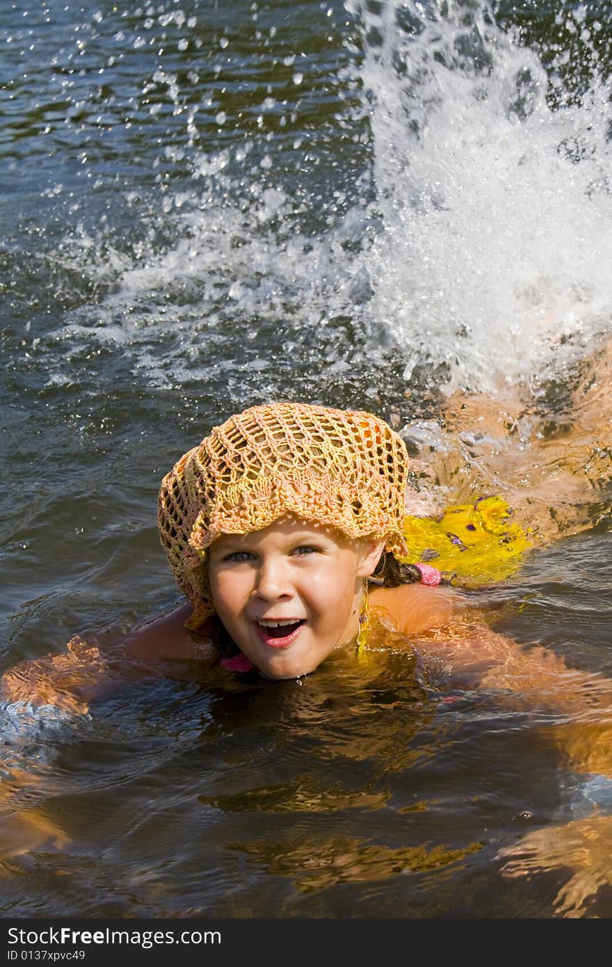 Little girl swimming in a river in the summer. Little girl swimming in a river in the summer