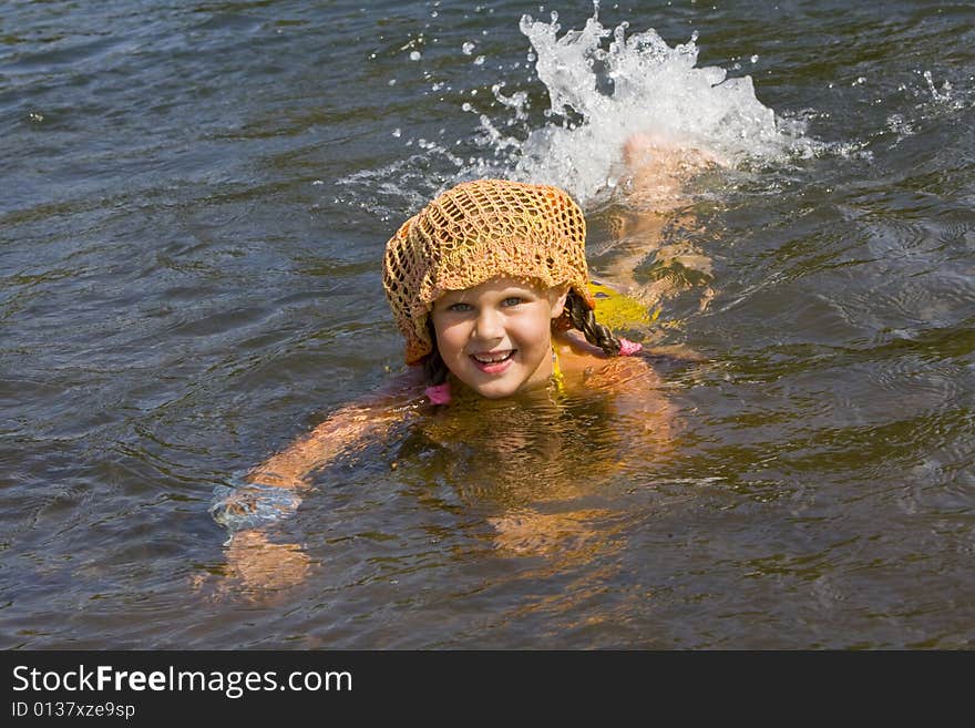 Little girl swimming in a river in the summer. Little girl swimming in a river in the summer