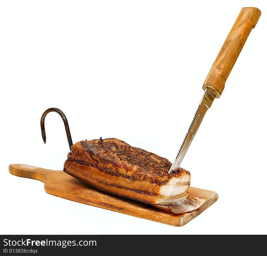 Smoked pork bacon on the wood tablet with knife and hook, domestic production. Smoked pork bacon on the wood tablet with knife and hook, domestic production