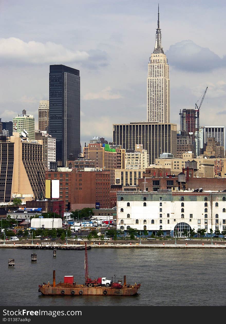 The view of the truck on a floating platform with Manhattan skyscrapers in a background (New York City). The view of the truck on a floating platform with Manhattan skyscrapers in a background (New York City).