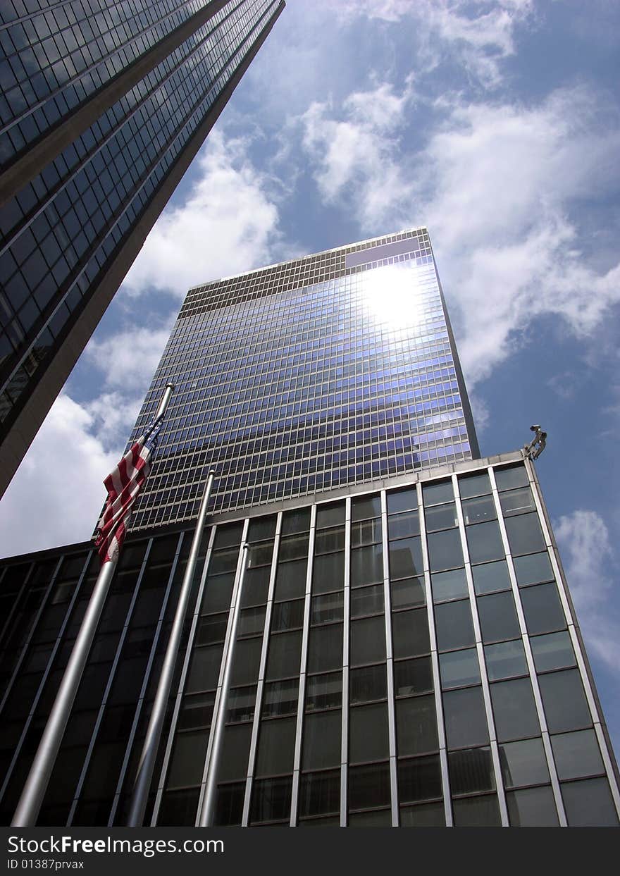 The view of tall skyscrapers with sunlight reflections in Manhattan, New York City. The view of tall skyscrapers with sunlight reflections in Manhattan, New York City.