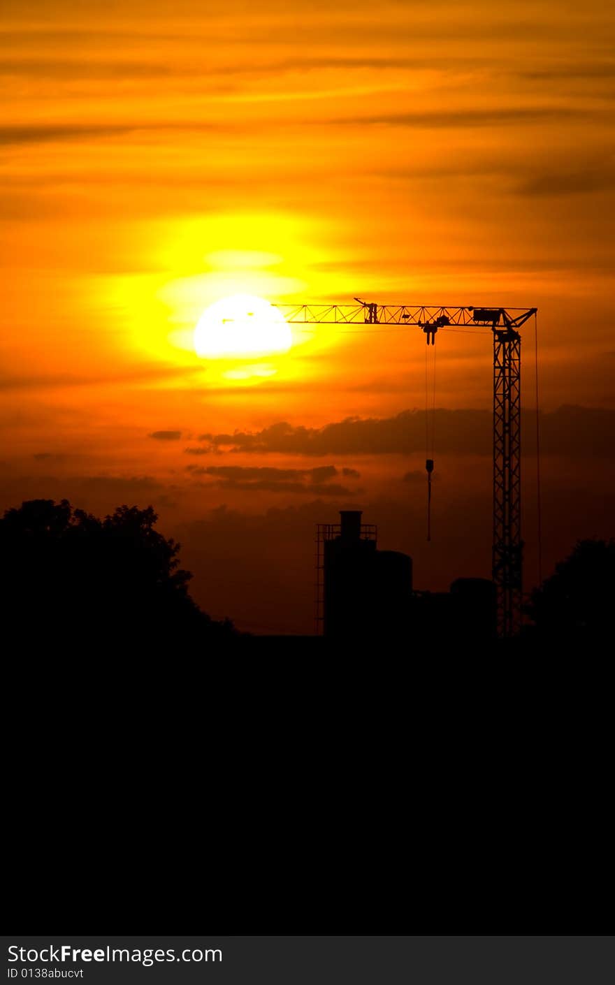 Sunset with a silhouette of a crane and factory. Sunset with a silhouette of a crane and factory