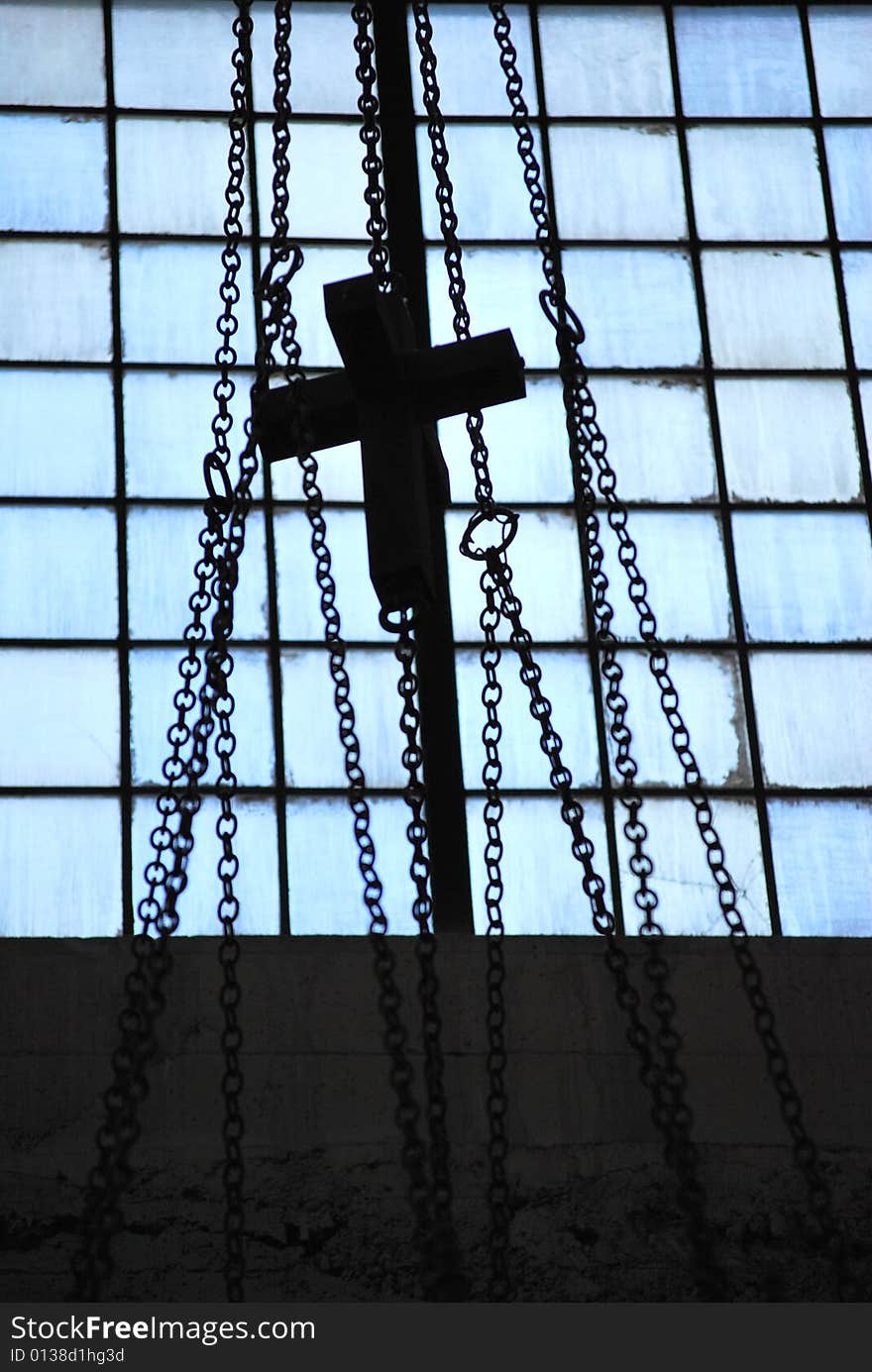 Cross hanging on chains inside a church.