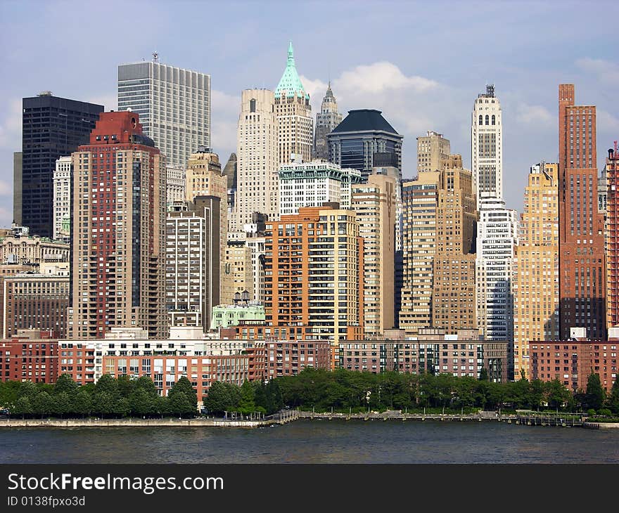 The view of lower Manhattan skyscrapers filled with evening sunlight (New York City). The view of lower Manhattan skyscrapers filled with evening sunlight (New York City).