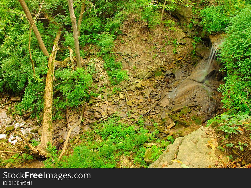 This is a bird eyes view of an open area near a small waterfall. This is a bird eyes view of an open area near a small waterfall.