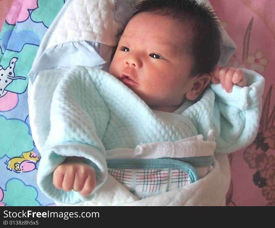 Lovely Baby in blue on a bed