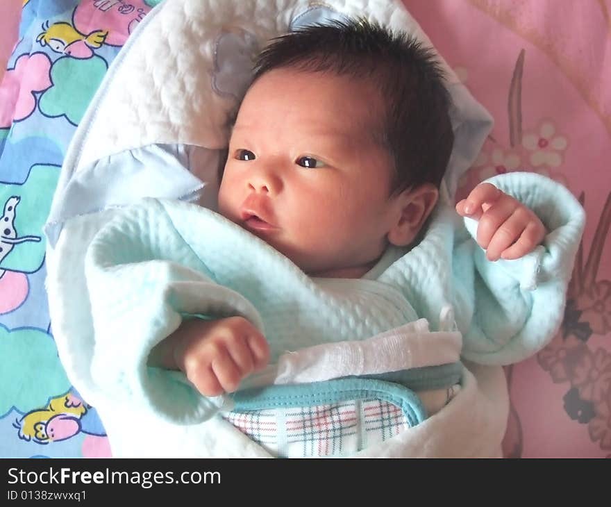 Lovely Baby in blue on a bed