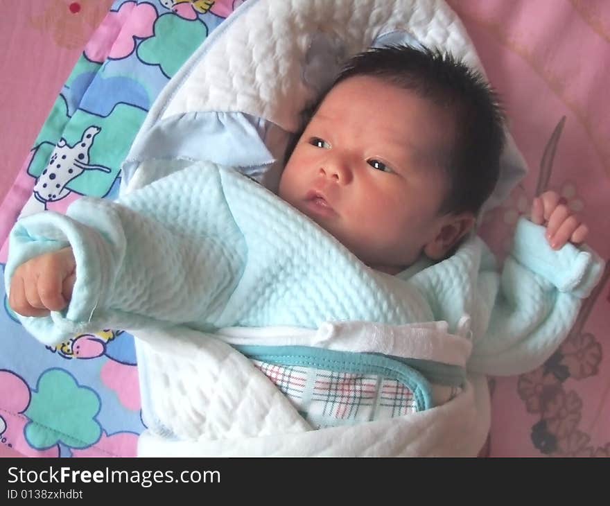 Lovely Baby in blue on a bed