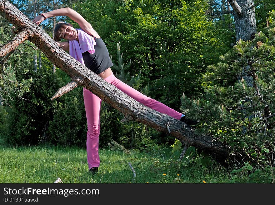 Young girl doing gymnastics in the nature with towel around neck. Young girl doing gymnastics in the nature with towel around neck