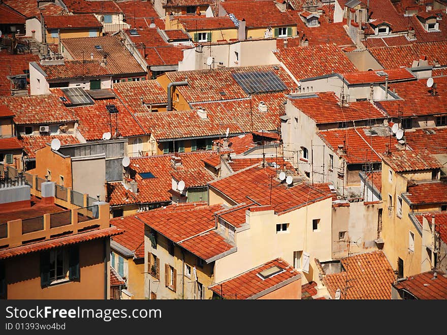 Equal red tile roofs in old residential district of Nice, dense building up, houses with white and yellow walls and open shutters,. Equal red tile roofs in old residential district of Nice, dense building up, houses with white and yellow walls and open shutters,