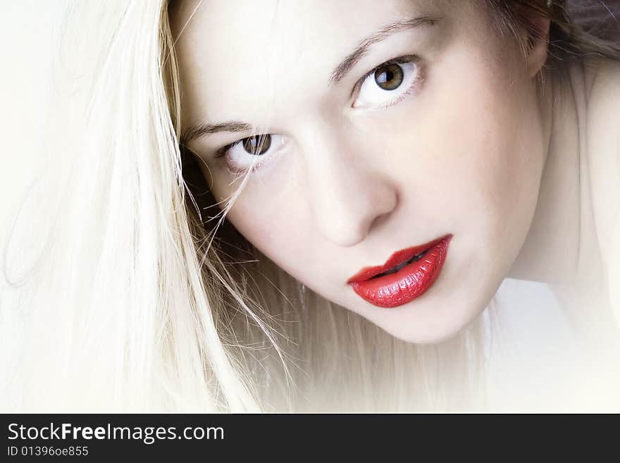 Woman with blond long hair and red lips; white background. Woman with blond long hair and red lips; white background