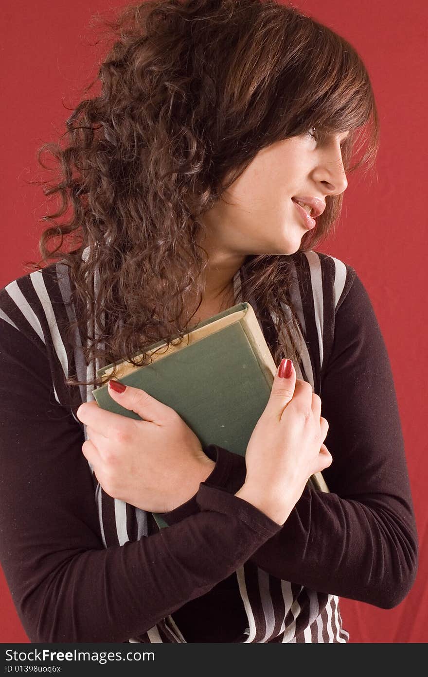 Young student girl with books on red backgrounds