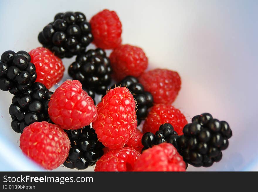 blackberry and raspberry in a blue bowl. blackberry and raspberry in a blue bowl