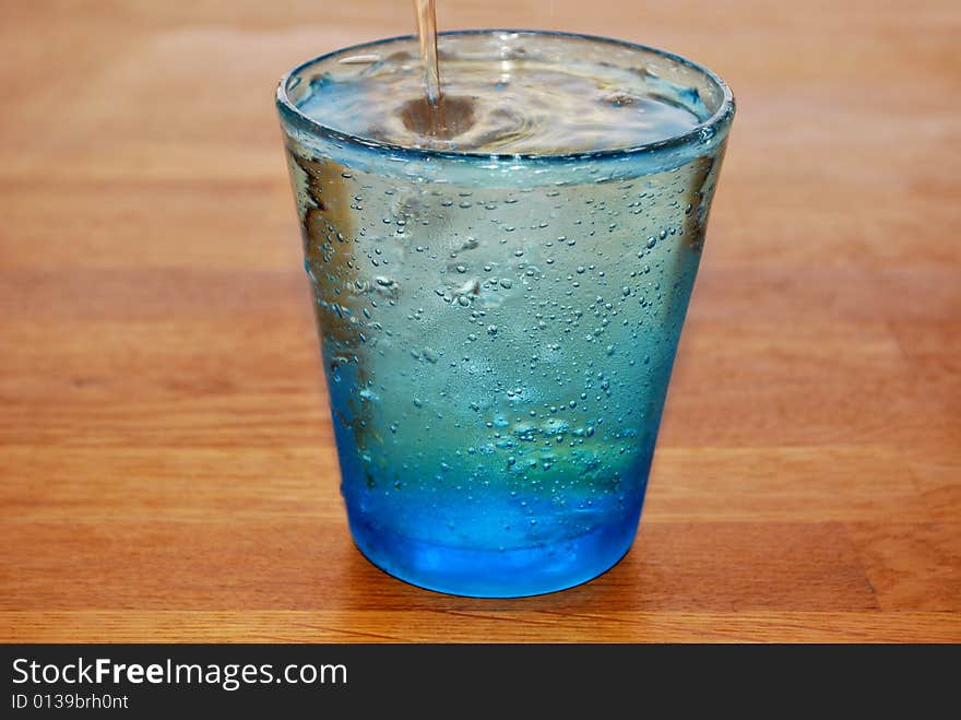 Glass of water overflowing on a table