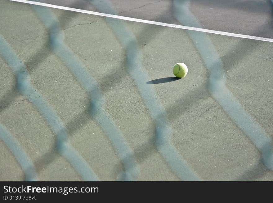 Single tennis ball left on the court - landscape exterior