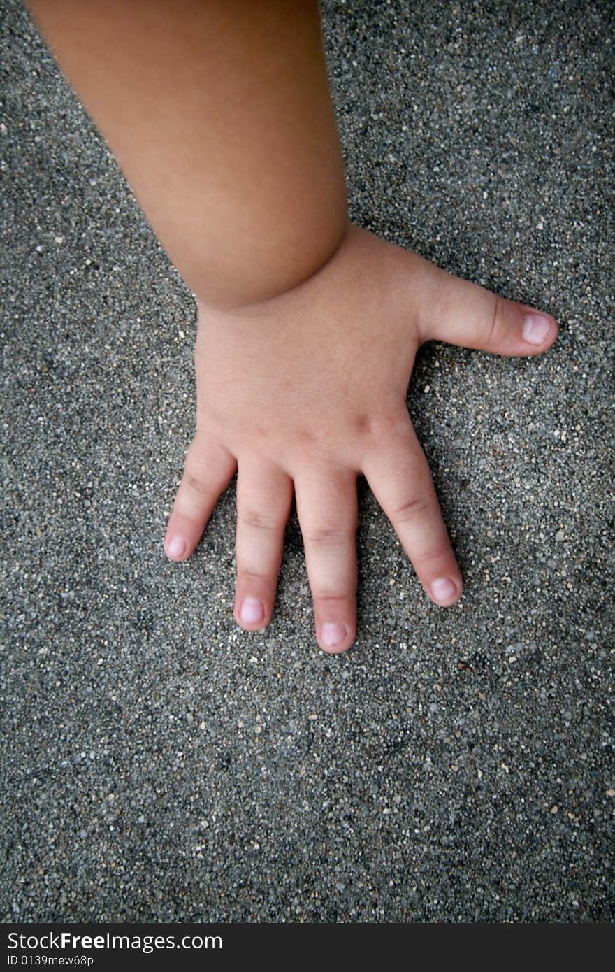 A baby hand on the floor.