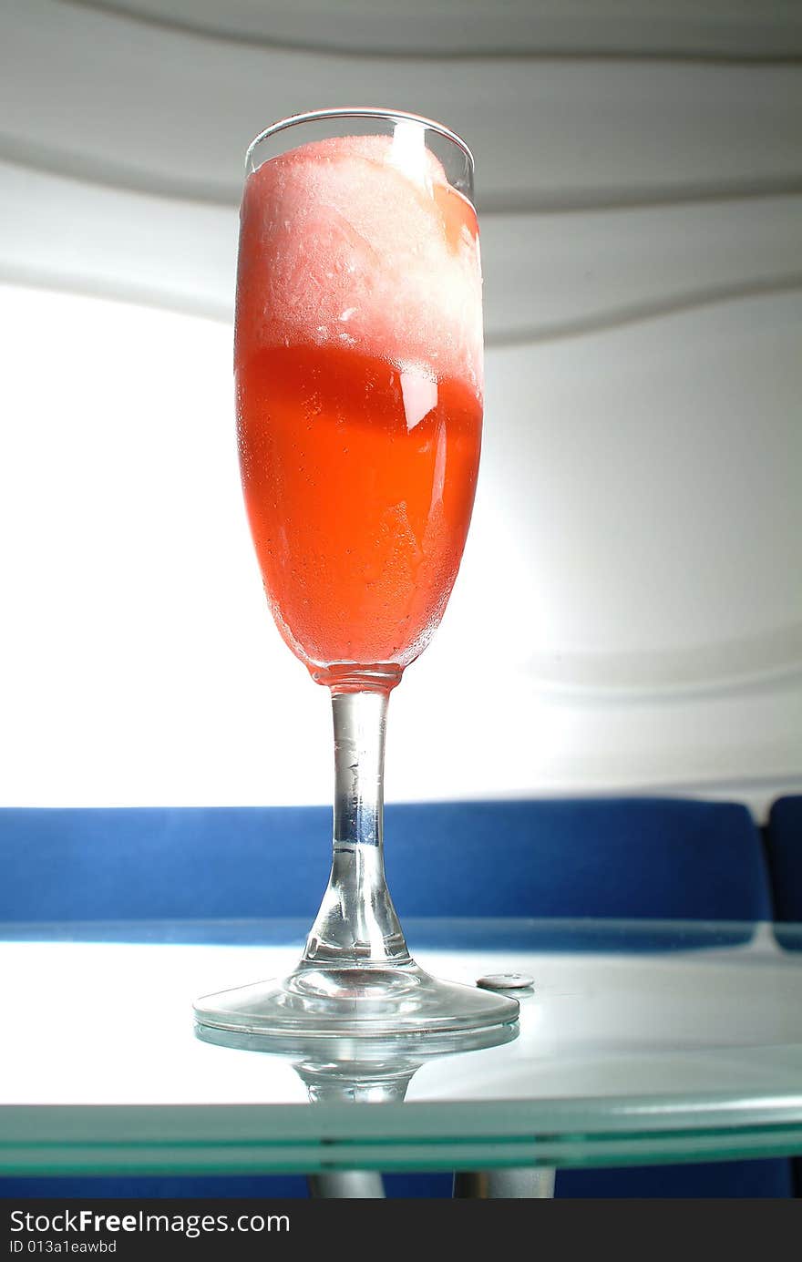 A red cocktail frappe in a bar Cristal table