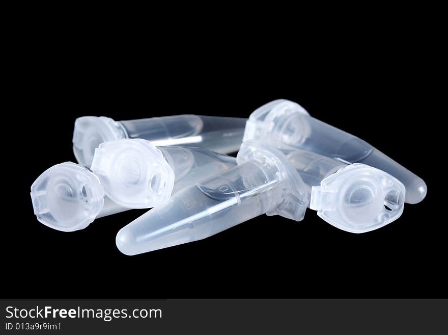 Empty eppendorf vials with white liquid isolated on black background