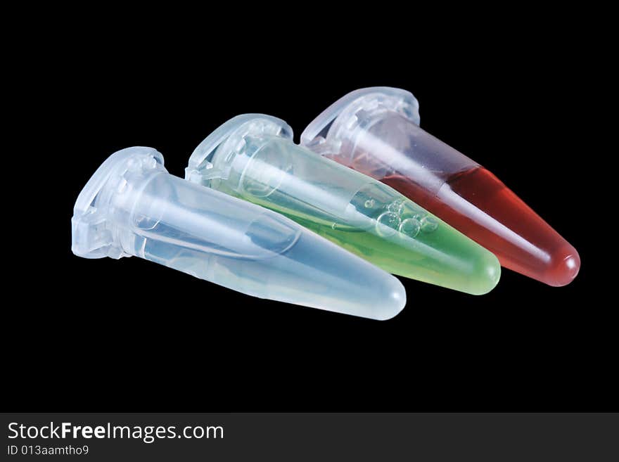 Eppendorf vials with white, red and green liquid isolated on black background