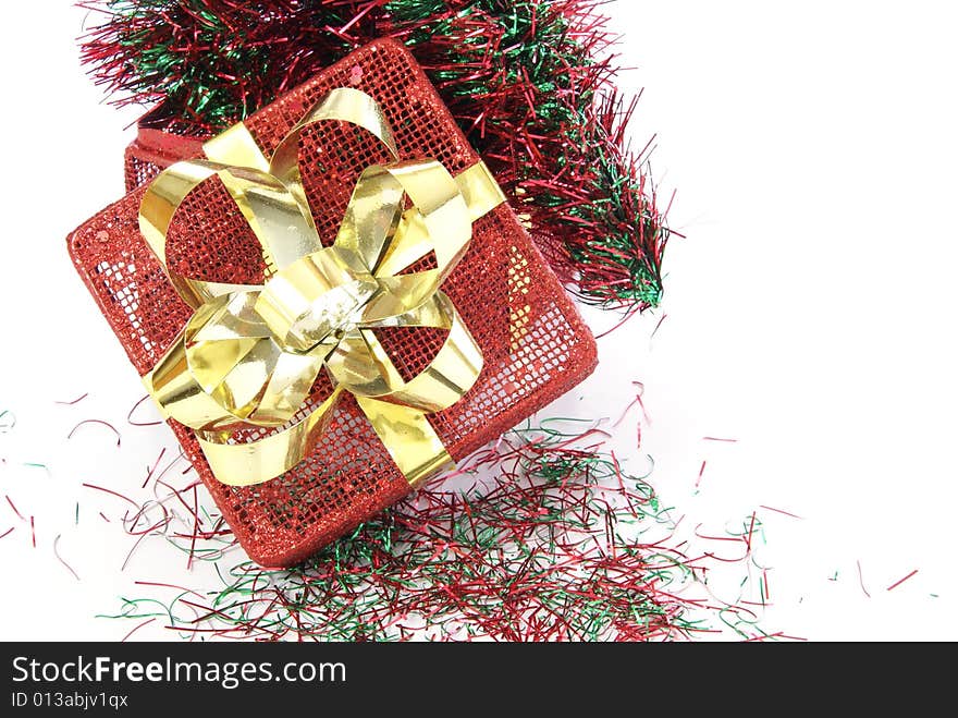 Red metal Christmas box with red and green garland inside.