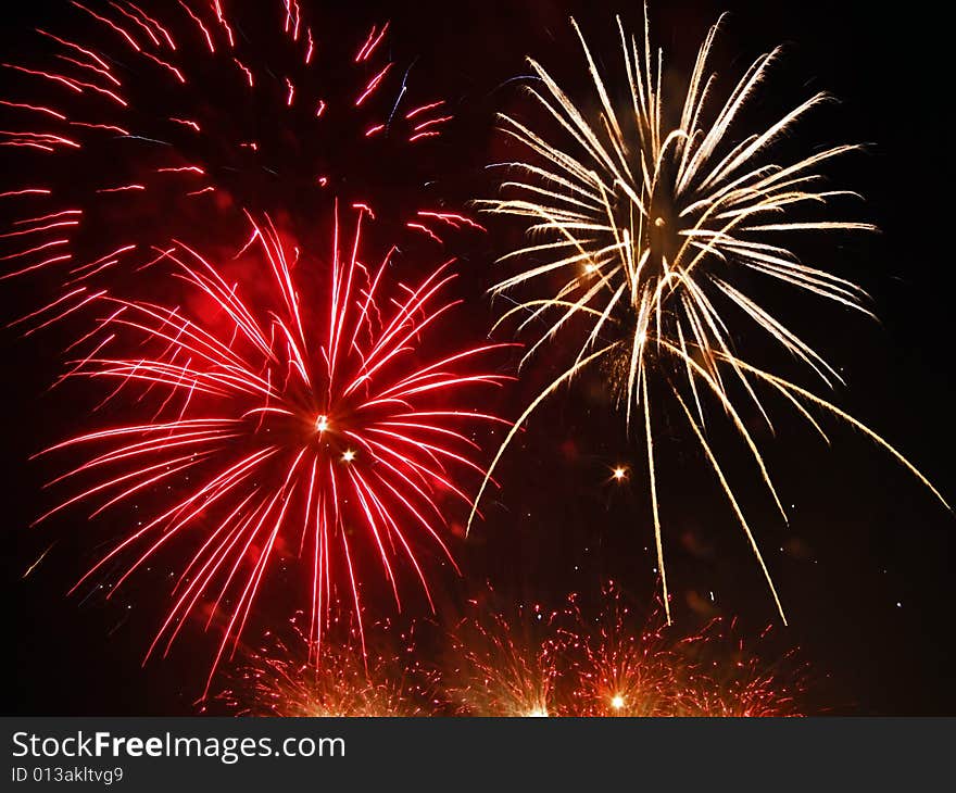 Large fireworks exploding high in the air in different colours