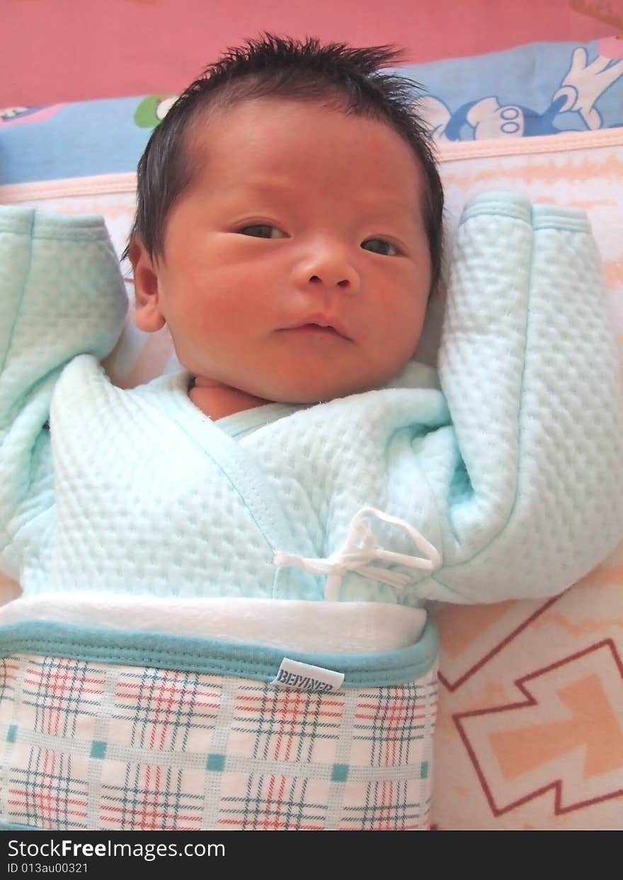 A pretty Chinese baby on a bed. A pretty Chinese baby on a bed