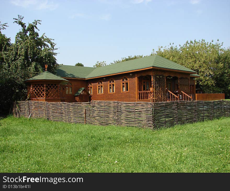 Greater rural log hut from round brown logs with a roof and a door. Greater rural log hut from round brown logs with a roof and a door