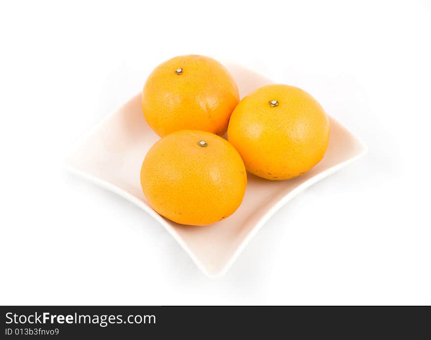 Oranges in white plate isolated on white background