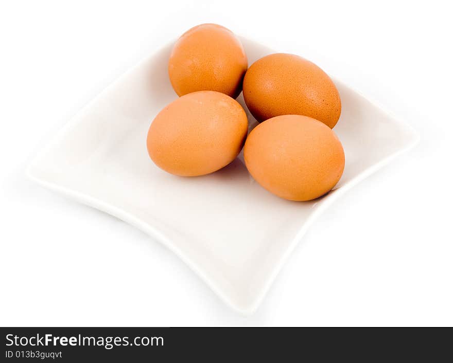 Brown eggs in white square plate isolated