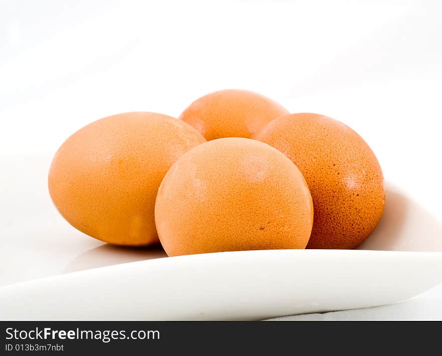 Brown eggs in white square plate isolated