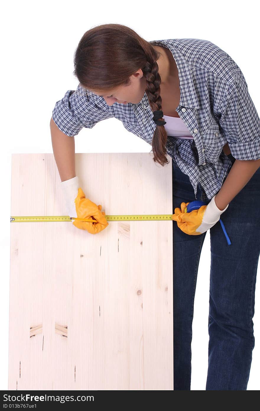 Woman carpenter with wooden plank and measuring tape