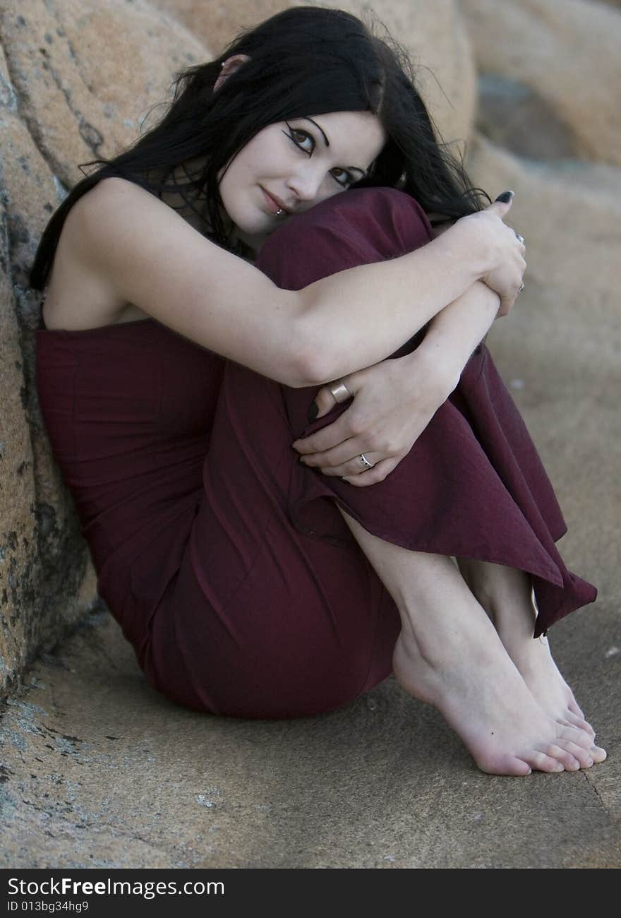 Woman sitting on a rock. Woman sitting on a rock