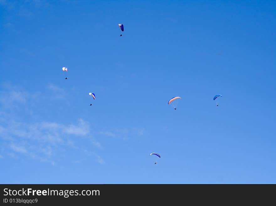 Plenty of paragliders are flying in the sky in the Alps, Bavaria, Germany. Plenty of paragliders are flying in the sky in the Alps, Bavaria, Germany