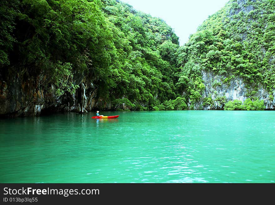 Woman With Canoe Rowing Past An Island