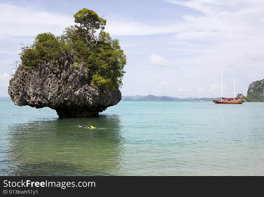 Male snorkeling in a bay with a boat in the background. Male snorkeling in a bay with a boat in the background