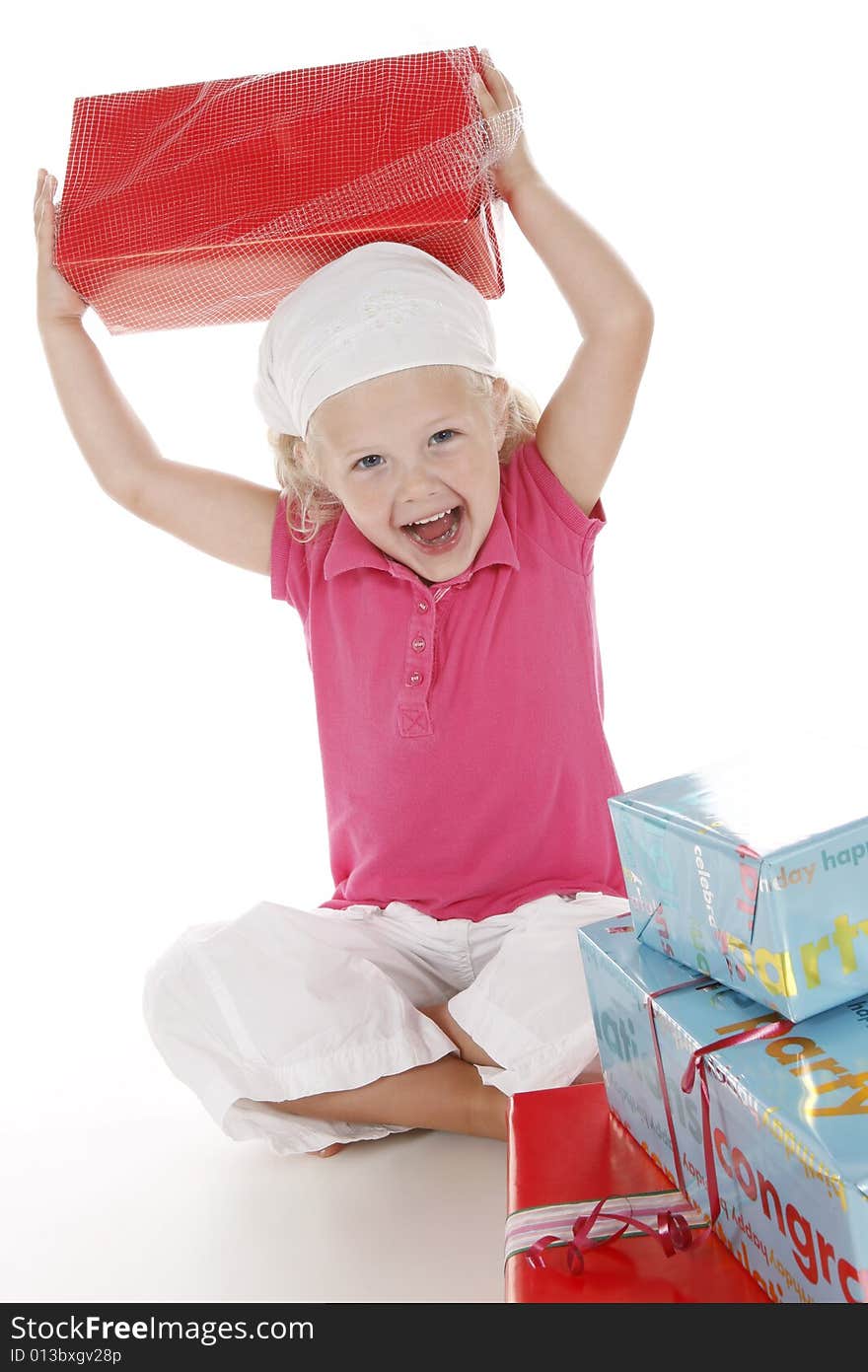 Cute little girl dressed in pink celebrating her birthday with several gifts. Cute little girl dressed in pink celebrating her birthday with several gifts