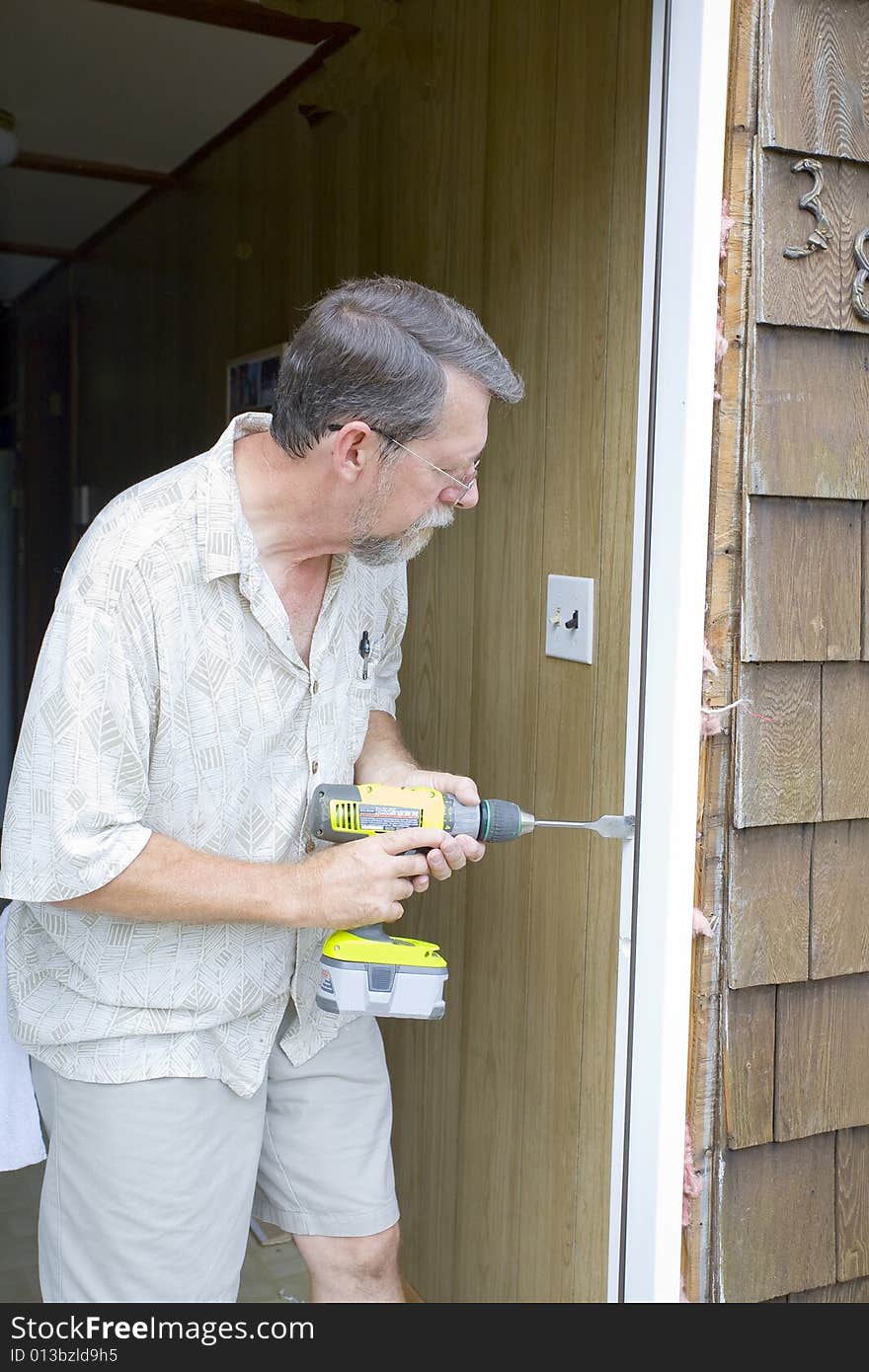 Elderly carpenter replacing exterior door frames, weather has promoted rot & chipping of the paint