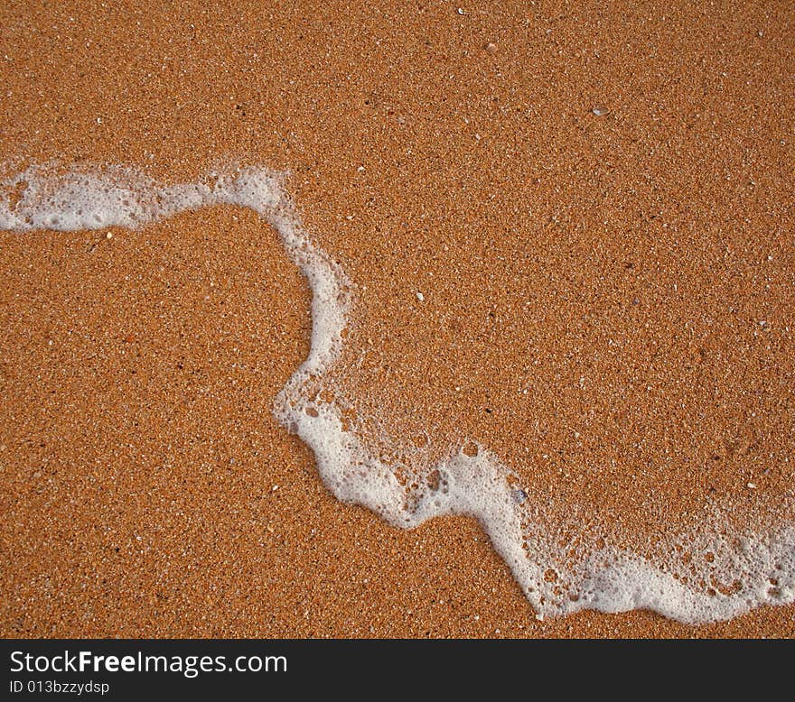 The sand of orange Raudisandur beach (Iceland) and foam left by the sea wave. The sand of orange Raudisandur beach (Iceland) and foam left by the sea wave.